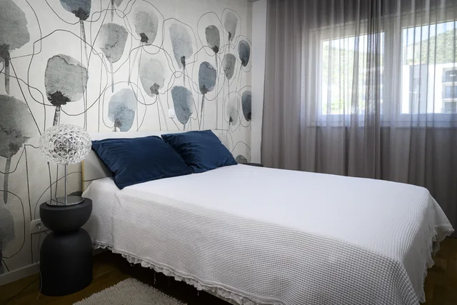Second bedroom with blue cushions and fitted wardrobes