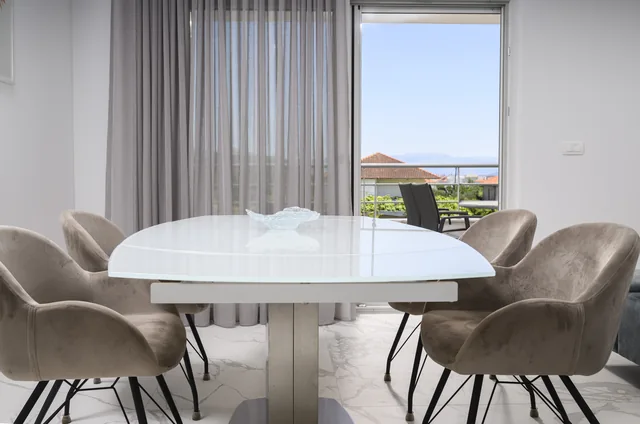 Apartment B dining table beside the balcony doors