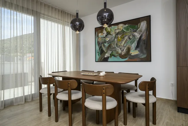 Penthouse dining table beside full-height windows