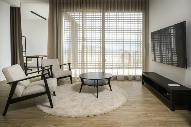 Separate lounge with armchairs, a coffee table and television