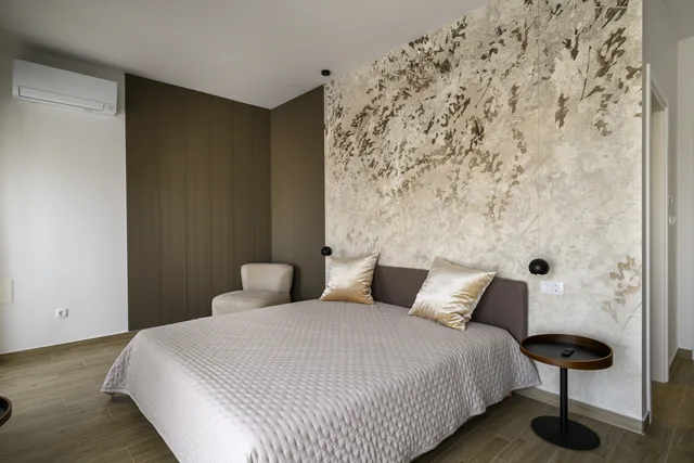 Third penthouse bedroom with a textured wall and an armchair