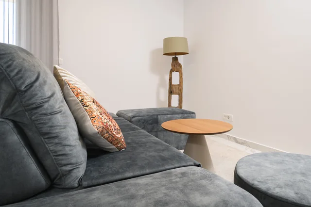 Corner sofa with cushions and wooden coffee tables