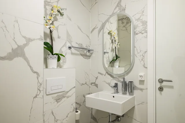 First bathroom with a shower, washbasin and round mirror
